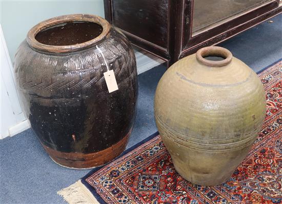 A large black glazed pottery jar and one other jar H.52cm